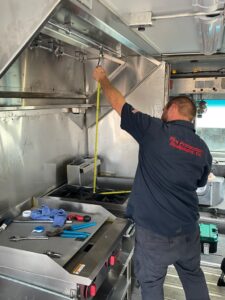 technician installing commercial kitchen fire suppression system